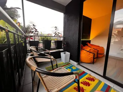a balcony with two chairs and a bed on it at POBLADO PARK LUXURY APARTMENT's in Medellín