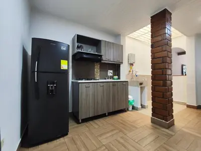 a kitchen with a black refrigerator in a room at Casa primer piso Laureles, Estadio, UPB, la 70 in Medellín