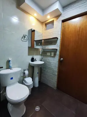 a bathroom with a toilet and a sink and a door at Casa primer piso Laureles, Estadio, UPB, la 70 in Medellín