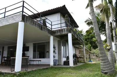 a house with a balcony and palm trees at Hostal Santa Teresita in La Merced