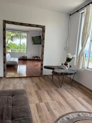 a living room with a table and a couch at Hostal Santa Teresita in La Merced
