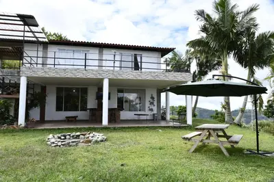 a house with a picnic table and an umbrella at Hostal Santa Teresita in La Merced
