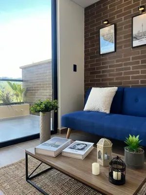 a living room with a blue couch and a coffee table at Casa Berlín, Lake Access in Guatapé