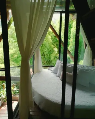 a bed in a room with a window at ATTRAVERSIAMO BAMBOO HOUSE in Manizales