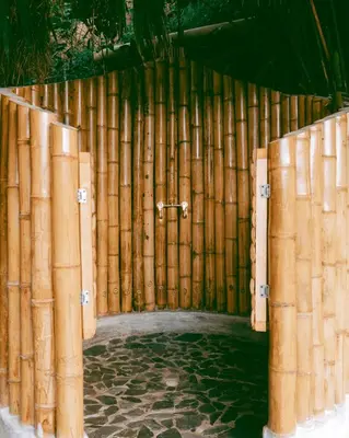 a bamboo fence with a door in the middle at ATTRAVERSIAMO BAMBOO HOUSE in Manizales