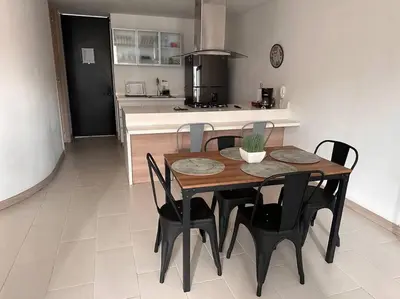 a kitchen with a wooden table and black chairs at Apartamento Lauret 2 en Laureles in Medellín