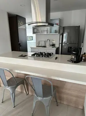 a kitchen with a counter and two chairs and a stove at Apartamento Lauret 2 en Laureles in Medellín
