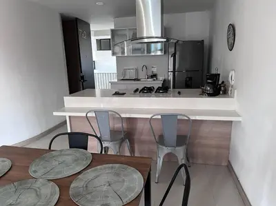 a kitchen with two tables and chairs and a counter at Apartamento Lauret 2 en Laureles in Medellín