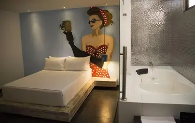 a bedroom with a bed and a painting on the wall at Hotel Medellin Arte in Medellín