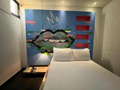 a bedroom with a bed with a painting of a mouth at Hotel Medellin Arte in Medellín