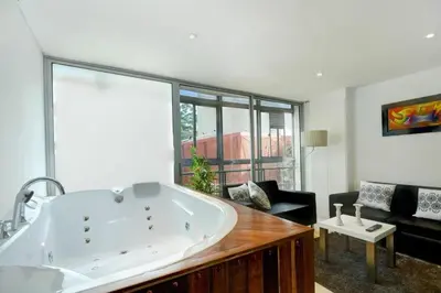 a large white tub in a room with a large window at Apartamento Lleras AC Hot Tub in Medellín