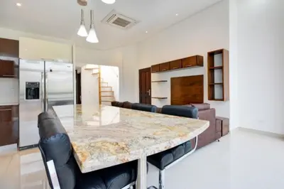 a kitchen with a large marble table and leather chairs at Apartamento Lleras AC Hot Tub in Medellín