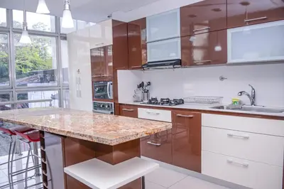 a kitchen with wooden cabinets and a marble counter top at Apartamento Lleras AC Hot Tub in Medellín