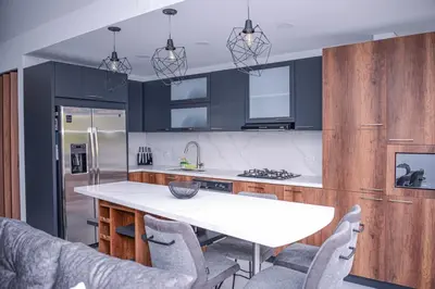 a kitchen with black cabinets and a white table and chairs at Apartamento Lleras AC Hot Tub in Medellín