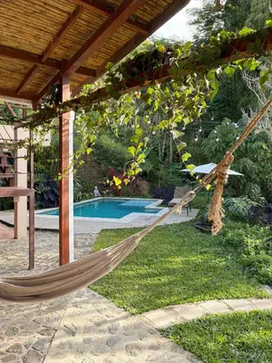 a hammock under a pergola next to a pool at Casa Nutabe - Casa de Campo en Girardota cerca a Medellín in Girardota