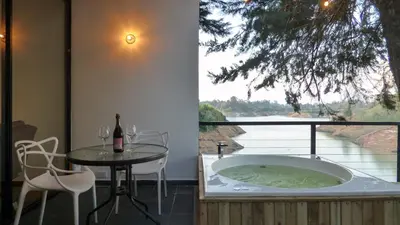a room with a tub and a table and a window at Tree House, Cabaña privada con Jacuzzi y canoa in Guatapé