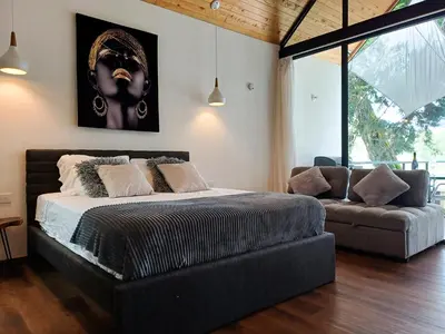 a bedroom with a bed and a couch at Tree House, Cabaña privada con Jacuzzi y canoa in Guatapé