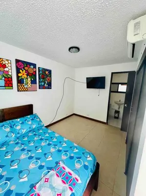 a bedroom with a bed and a tv in it at Apartasol Santa Fe de Antioquia in Santa Fe de Antioquia