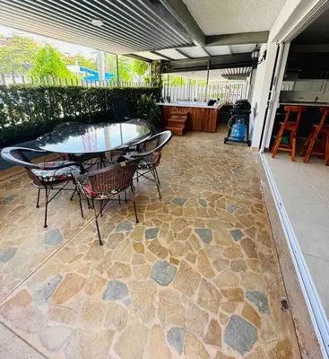 a patio with a table and chairs on a stone floor at Apartasol Santa Fe de Antioquia in Santa Fe de Antioquia