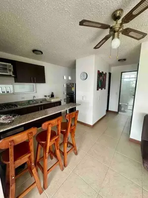 a kitchen with a table and chairs and a ceiling fan at Apartasol Santa Fe de Antioquia in Santa Fe de Antioquia