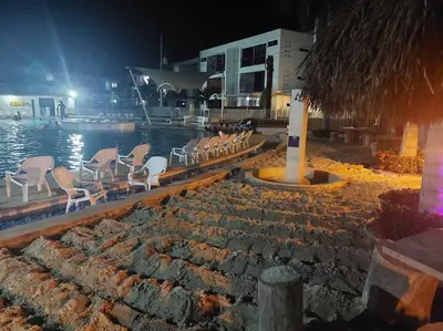 a group of chairs sitting by the water at night at Apartasol Santa Fe de Antioquia in Santa Fe de Antioquia