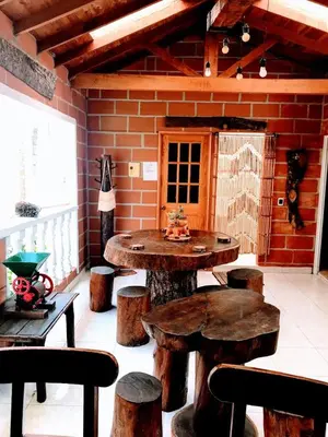a room with wooden tables and stools and a brick wall at Villa Luz in San Jerónimo