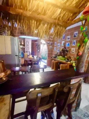 a restaurant with a large wooden table and chairs at Villa Luz in San Jerónimo