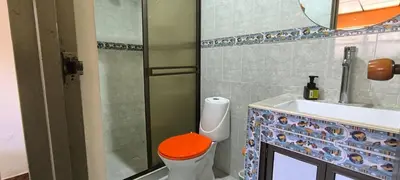 a bathroom with a toilet with an orange seat next to a sink at Apartaestudio central con balcón y wifi en Riosucio in Ruiosucio