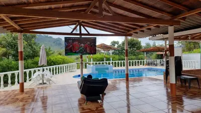 a living room with a pool and a screened in porch at Cabaña del lago in Cocorná