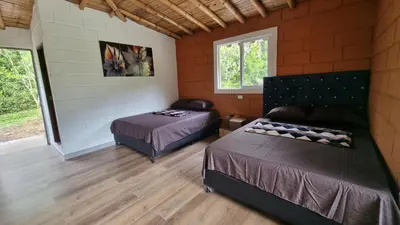 a bedroom with two beds and a couch at Cabaña del lago in Cocorná