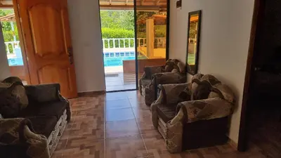 a row of chairs in a room with a pool at Cabaña vacacinal in Cocorná