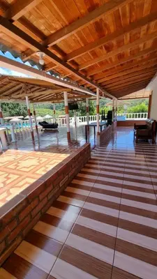 an outdoor patio with a wooden roof and floors at Cabaña vacacinal in Cocorná