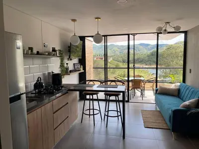 a kitchen and living room with a couch and a table at Nuevo apto con acceso al embalse en Guatapé in Guatapé