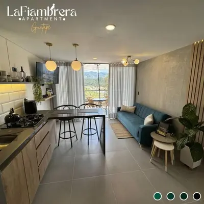 a kitchen and a living room with a blue couch at Nuevo apto con acceso al embalse en Guatapé in Guatapé