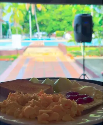 a plate of food with bread and fruit on a table at Hotel Aero Santa Fe in Santa Fe de Antioquia