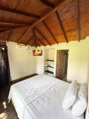 a bedroom with a white bed with a wooden ceiling at Hotel Aero Santa Fe in Santa Fe de Antioquia
