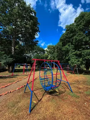 a playground with a red and blue swing at Hotel Aero Santa Fe in Santa Fe de Antioquia