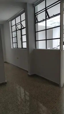 an empty room with two windows in a building at Casa en Laureles Ideal para Familias in Medellín