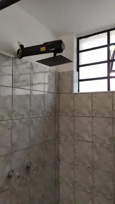 a bathroom with a window and a tiled wall at Casa en Laureles Ideal para Familias in Medellín