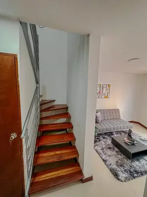 a staircase in a living room with a couch at Apartamento Duplex en ubicacion privilegiada in Manizales