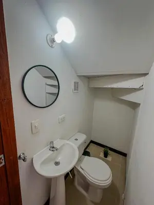 a bathroom with a sink and a toilet and a mirror at Apartamento Duplex en ubicacion privilegiada in Manizales