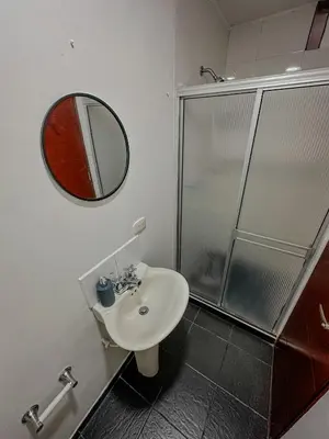 a bathroom with a sink and a shower with a mirror at Apartamento Duplex en ubicacion privilegiada in Manizales