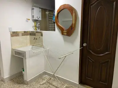a bathroom with a mirror and a shelf and a door at Acogedora casa en Bello Antioquia in Bello