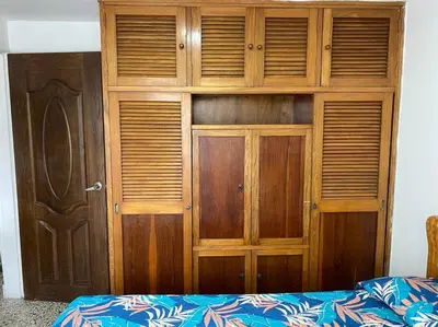 a wooden closet with wooden doors in a bedroom at Acogedora casa en Bello Antioquia in Bello