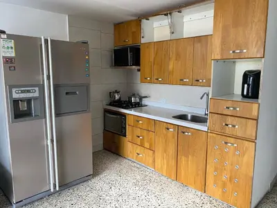 a kitchen with wooden cabinets and stainless steel appliances at Acogedora casa en Bello Antioquia in Bello
