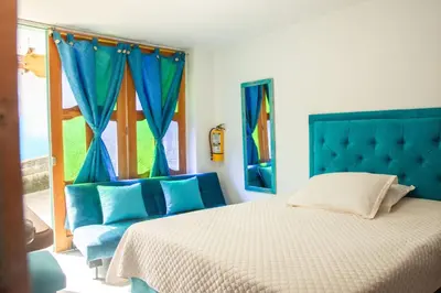 a bedroom with a blue bed and a window at Habitación La Amelia in Jericó