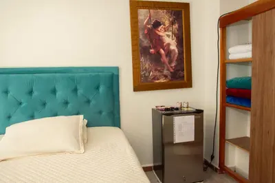 a bedroom with a bed and a painting on the wall at Habitación La Amelia in Jericó