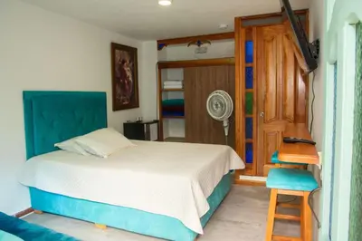 a bedroom with a bed and a chair and a door at Habitación La Amelia in Jericó