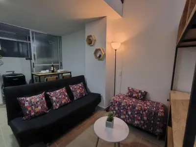 a living room with a black couch and a table at Apartaestudio completo en Itagüí - Shalom - 501 in Itagüí