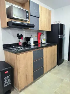 a kitchen with a microwave and a black refrigerator at Apartaestudio completo en Itagüí - Shalom - 501 in Itagüí